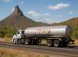 Camión cisterna de Combustóleo de Sonora realizando distribución de combustible en el norte de México, con paisaje desértico y cerro de fondo.